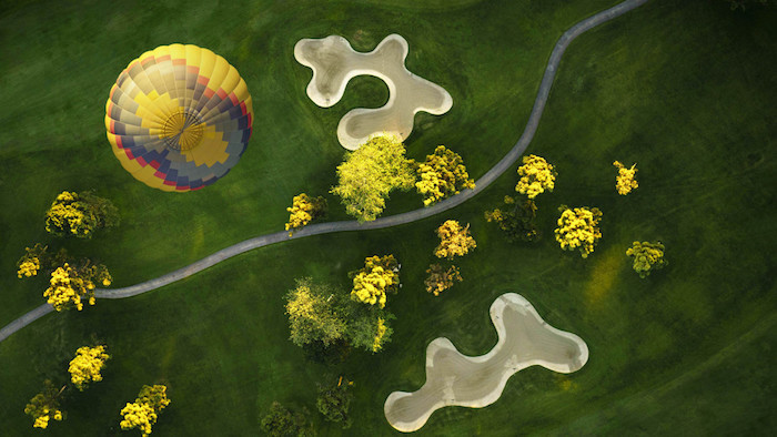 Hot Air Balloon over a Golf Course by M. M_Kloskowski