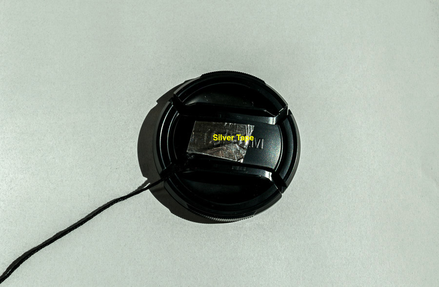 Thick black thread attached to lens cap