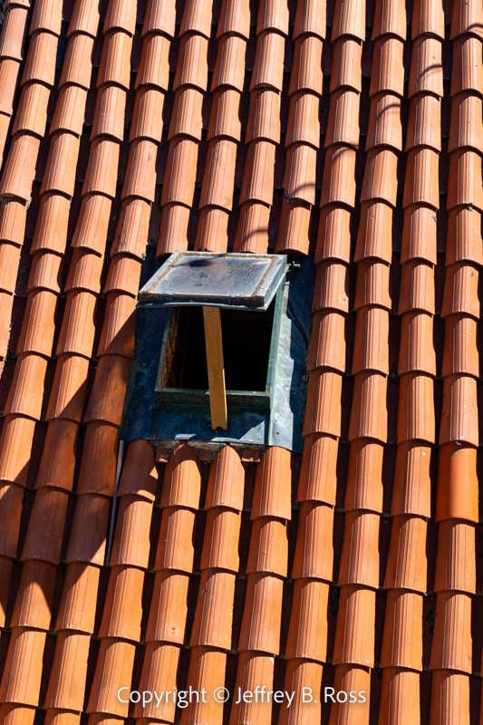 Old Town house roof with window propped open